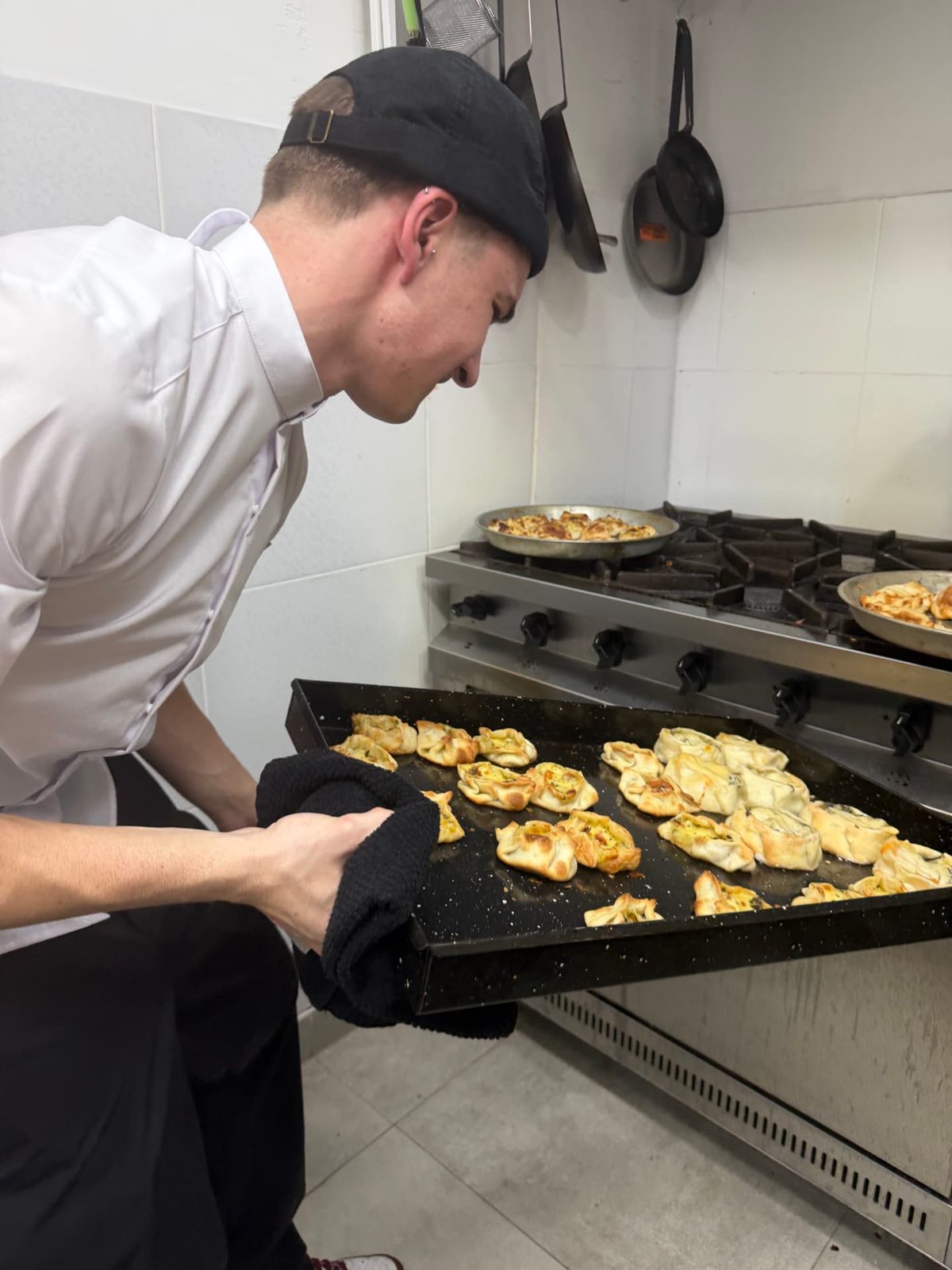 Cocinero sacando la comida del horno en la cocina de Dapont